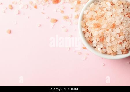 Bowl of pink himalayan salt on pink background Stock Photo