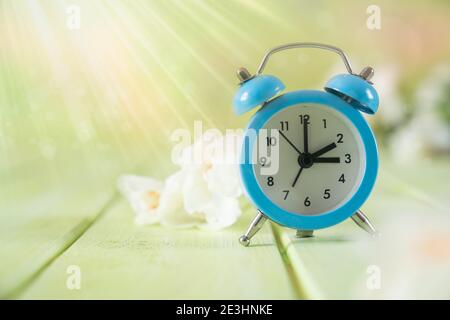 Spring time daylight saving concept - with alarm clock and flowers Stock Photo