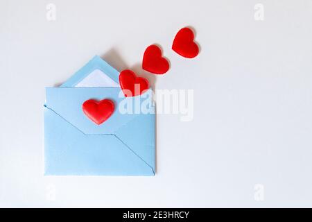 Blue envelope and flying red hearts on white background. Love letter with hearts and copy space. Gratitude to doctors and nurses. Valentines, Mother, Stock Photo