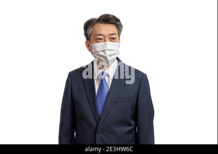 Portrait of a middle-aged Asian businessman wearing a white face mask. White Background. Covid19, Health, and Business Concepts. Stock Photo