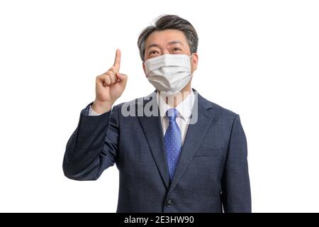 Portrait of a middle-aged Asian businessman wearing a white face mask. White Background. Covid19, Health, and Business Concepts. Stock Photo