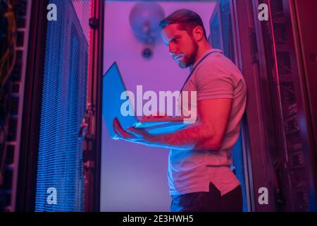Software specialist with laptop in service room Stock Photo