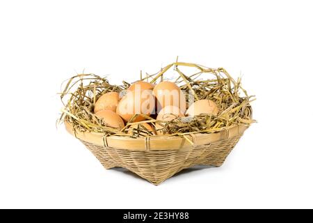 Group of eggs with straw in a bamboo basket isolated on white background. Stock Photo