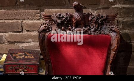 Vintage medieval board game known as Cathedral set on a small table near a carved wooden armchair with red velvet tapestry Stock Photo