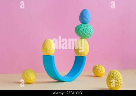 Easter minimalistic decor concept. Geometric Easter eggs standing on top of each other on pink background with blank space for text. Stock Photo