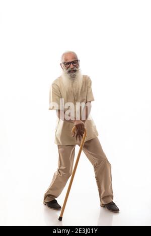 AN OLD MAN WITH STICK IN HAND HAPPILY DANCING Stock Photo