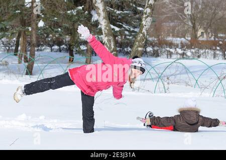 Two laughing little girls playing in snowdrifts fooling around, city park. January 29, 2012. Kyiv, Ukraine Stock Photo