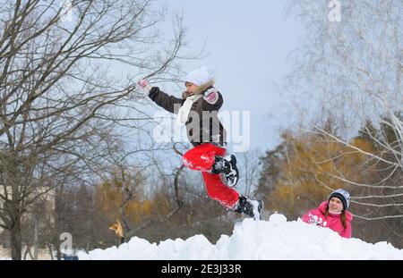 Two laughing little girls playing in snowdrifts fooling around, city park. January 29, 2012. Kyiv, Ukraine Stock Photo