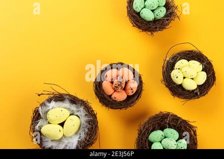 Bird nests with eggs on a colored background, Easter concept. Top view, selective focus, copy space Stock Photo