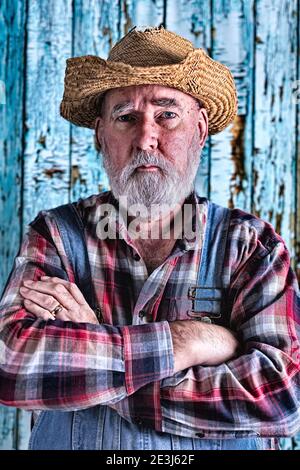 Elderly man in bib overalls. Post-processed for added drama. Stock Photo