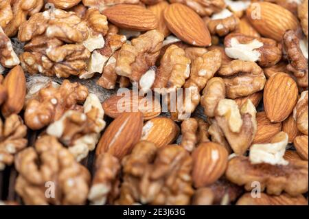 Almonds and walnuts scattered on the table. Close-up, selective focus Stock Photo