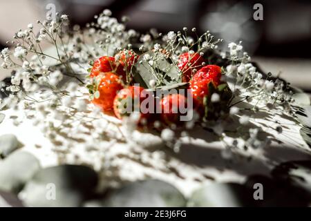Close up of rustic wedding cake decorated with gypsophila and strawberries Stock Photo