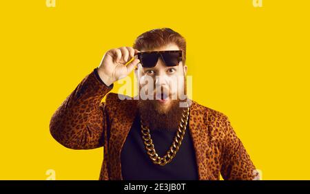 Funny smiling red haired bearded man hipster putting off sunglasses and feeling surprised Stock Photo