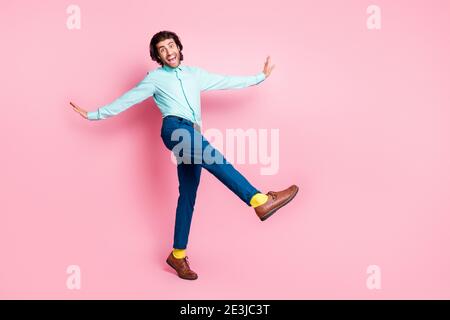 Full body photo of crazy energetic brown hair man have fun crazy go walk isolated over pink color background Stock Photo