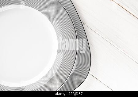The modern classical porcelain set of plates stands on a white table Stock Photo