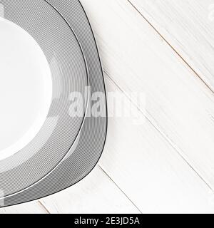 The modern classical porcelain set of plates stands on a white table Stock Photo