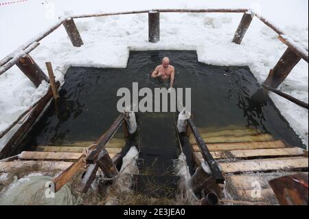 Saint Petersburg, Russia. 19th Jan, 2021. An Orthodox Christian dives into iced water during the Epiphany celebration in St. Petersburg, Russia. Orthodox Christians celebrate the Epiphany by immersing themselves in ice water, the religious holiday which is celebrated on 19 January according to the Gregorian calendar. Credit: SOPA Images Limited/Alamy Live News Stock Photo