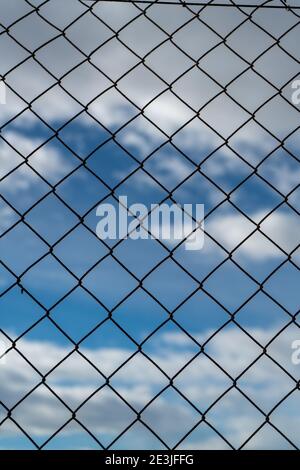 Chain link fence against a cloudy sky Stock Photo