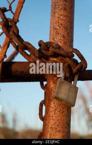Rusty iron chain and lock closes iron gate Stock Photo