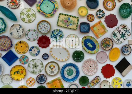 Many different and colorful plates and bowls hanging on the wall Stock Photo