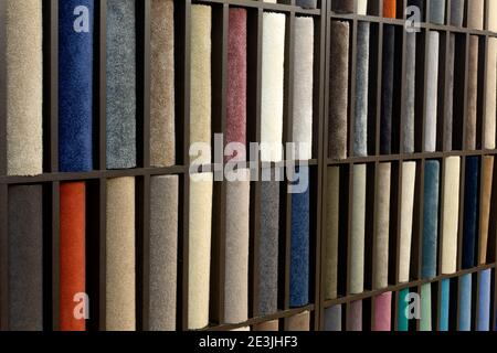 Samples of colored carpets at the stand. Various carpet designs for the interior. Stock Photo