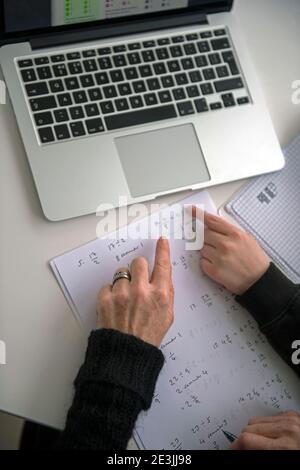 A child being home schooled/distance learning with the help of a parent in the UK while both secondary and primary schools across the UK are still clo Stock Photo
