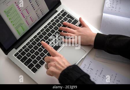 A child being home schooled/distance learning with the help of a parent in the UK while both secondary and primary schools across the UK are still clo Stock Photo