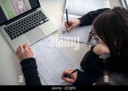 A child doodling while being home schooled with the help of a parent in the UK while both secondary and primary schools across the UK are still closed Stock Photo