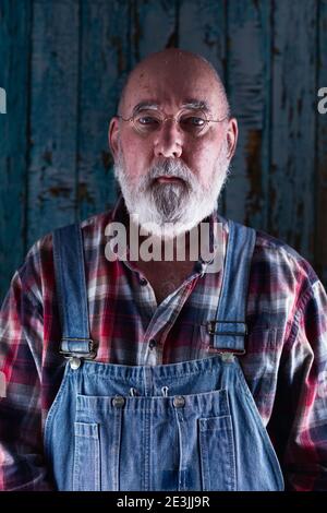Portrait of an elderly man in bib overalls. Stock Photo