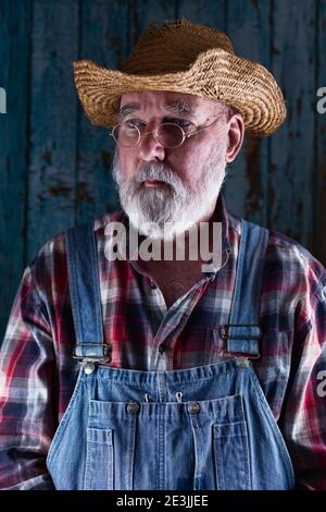 Portrait of an elderly man in bib overalls. Stock Photo