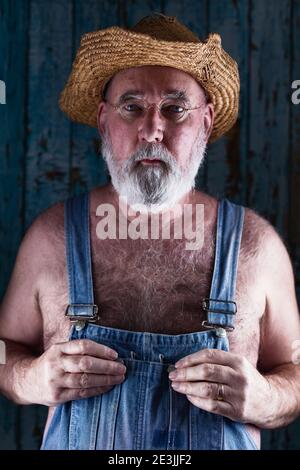 Portrait of an elderly man in bib overalls. Stock Photo