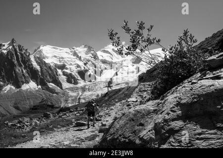 Young woman hiking at Plan Praz with breathtaking view of Aiguille du Midi in Mont Blanc mountains within the French Alps in summer. Black white photo Stock Photo