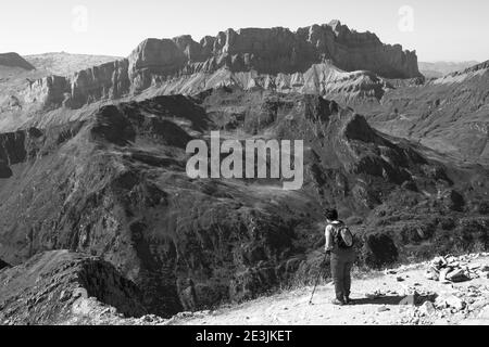 Senior woman with Nordic walking stick admiring Alpine mountain landscape. France. Elderly wellness, longevity concept.  Black white historic photo Stock Photo