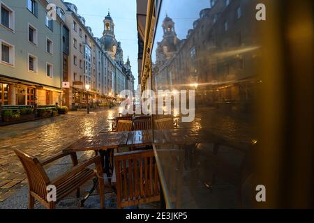 Dresden, Germany. 19th Jan, 2021. View in the afternoon through a bridge arch into the deserted Münzgasse, in the background the Frauenkirche can be seen which is reflected in an empty showcase for menus of a restaurant. Credit: Robert Michael/dpa-Zentralbild/dpa/Alamy Live News Stock Photo
