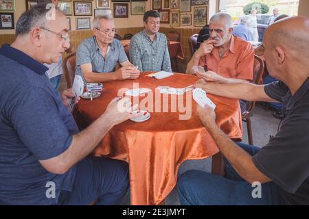 Istanbul, Turkey - September 17 2017: View through a window at local Turkish men playing a card game in the multicultural and authentic Istanbul neigh Stock Photo