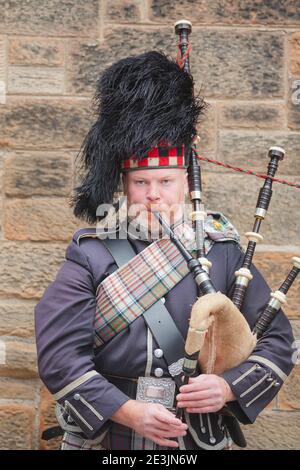 Edinburgh, Scotland - August 6 2017: A Scottish bagpiper performs along the Royal Mile in Edinburgh Old Town during the Fringe Festival. Stock Photo