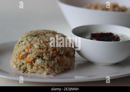 Dalia upma or broken wheat upma is a south Indian breakfast food made with broken wheat, mix veggies and other basic tempering ingredients served with Stock Photo