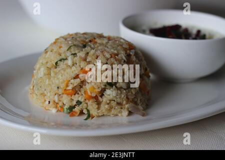 Dalia upma or broken wheat upma is a south Indian breakfast food made with broken wheat, mix veggies and other basic tempering ingredients served with Stock Photo