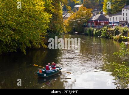 Autumn view of couple in a rowing boat on the River Derwent in Matlock Bath a village in the Derbyshire Dales area of the Peak District England UK Stock Photo