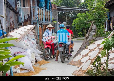 Sheets of edible rice paper, used for making fresh or fried spring rolls in Vietnamese cuisine drying in street, Mekong Delta, southwestern Vietnam Stock Photo