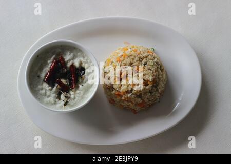 Dalia upma or broken wheat upma is a south Indian breakfast food made with broken wheat, mix veggies and other basic tempering ingredients served with Stock Photo