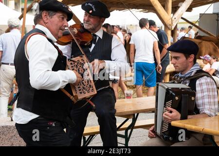 BOURG-SAINT-MAURICE, FRANCE - AUGUST 19, 2018: Musicians play accordion and violin during traditional Agricultural and Mountain Fair market at Savoie Stock Photo