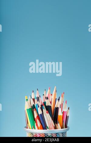 Colorful pencils in a metal jar on a blue background. The concept of creativity, the space Stock Photo