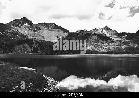 Savoie,France. Mountains and sky reflection in Alpine lake in Sassiere valley. Black and white photo. Stock Photo