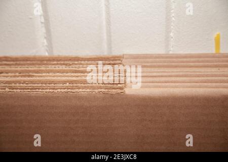 Seven unused, flattened cardboard boxes against an off-white wall Stock Photo