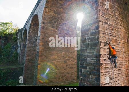 Man climbing up on man made viaduct in Sheffield Stock Photo