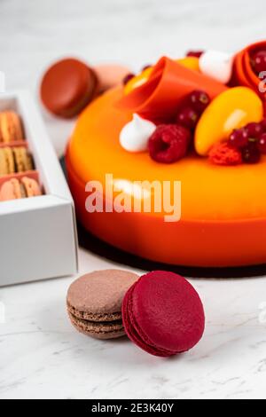 Orange, Mango, Raspberry Fruit Anniversary Birthday Cake and Colorful Homemade French Macarons Stock Photo