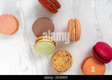 Colorful Fruity Macarons Flat Lay and Top View on White Marble Table Stock Photo