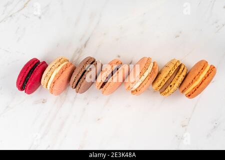 Colorful Fruity Macarons Flat Lay and Top View on White Marble Table Stock Photo