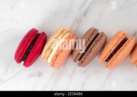 Colorful Fruity Macarons Flat Lay and Top View on White Marble Table Stock Photo